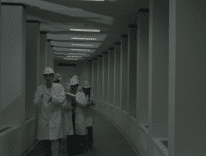 A group of scientists in lab coats and hard hats discuss parallel universes at the Washington Township Facility