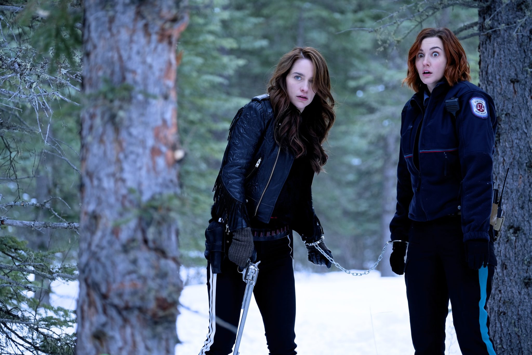 Wynonna and Nicole handcuffed together in the woods.