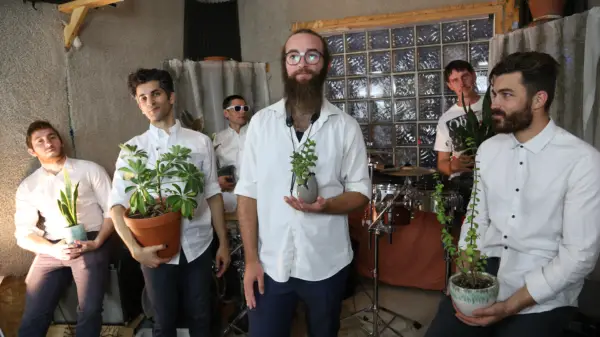Members of the band Kuwaisiana holding plants.