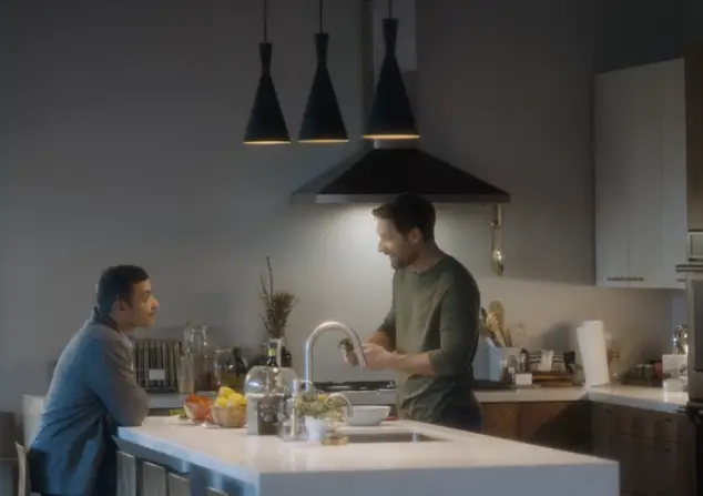 Arab and white man sitting at kitchen island. 