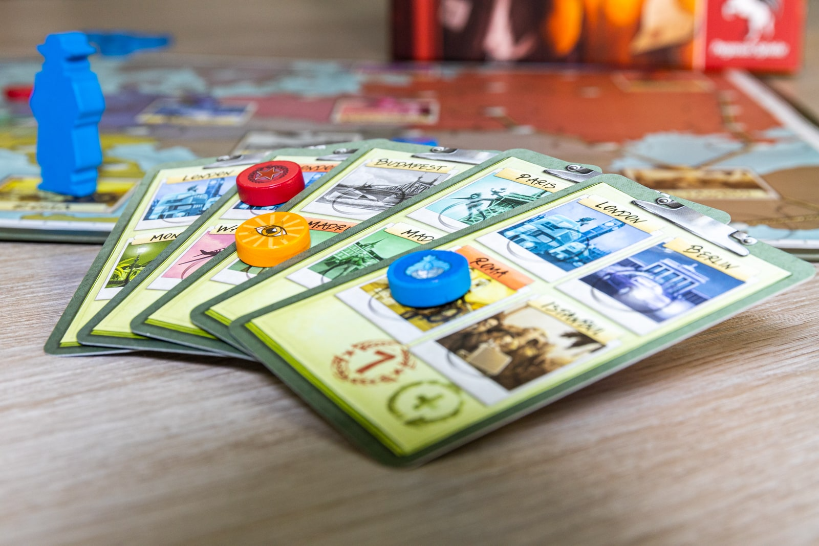 'Spy Connection' is Surprisingly Difficult to Understand 2 Spy Connection starting mission cards with agent disks and spy figurine set up on a table.