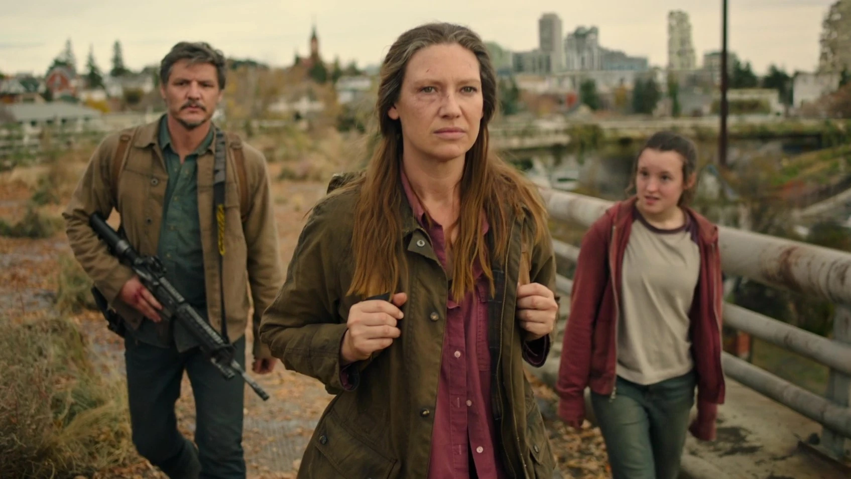 Tess, Joel and Elli walk on a bridge.