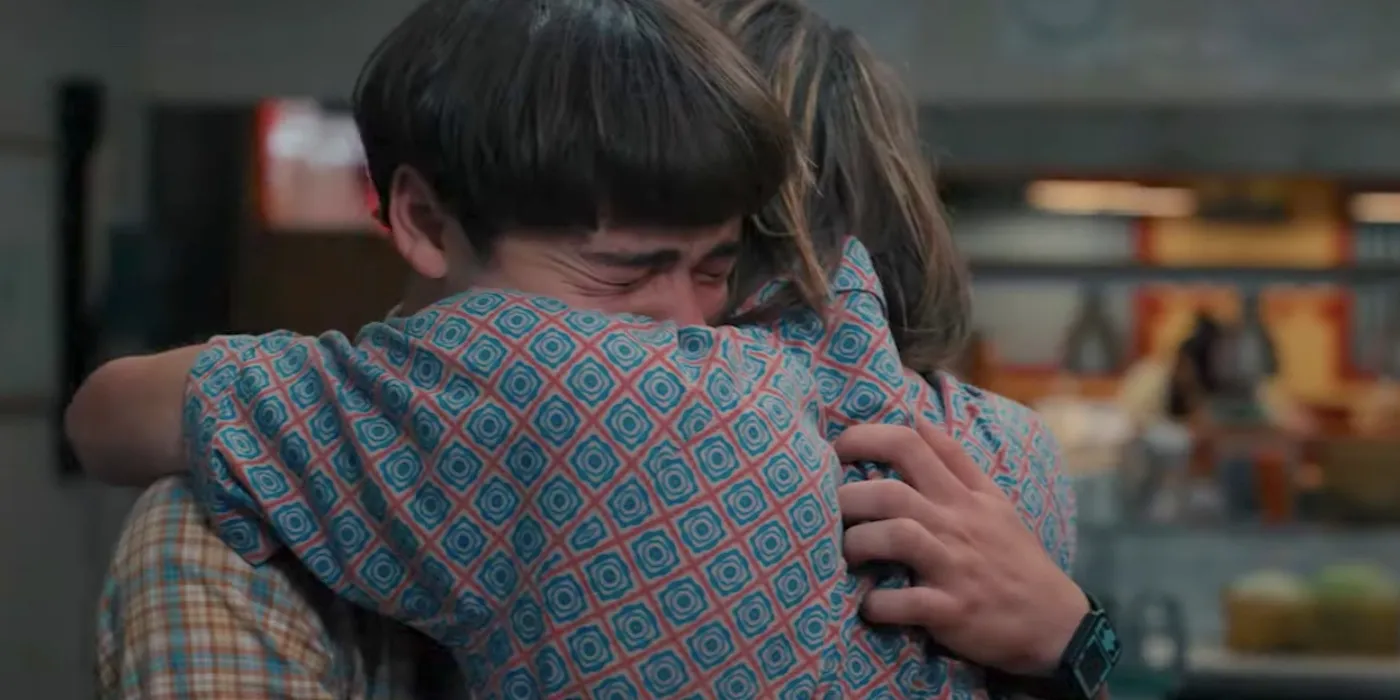 Jonathan (older brother) and Will (younger brother) from Stranger Things hug and Will cries into Jonathan's shoulder.