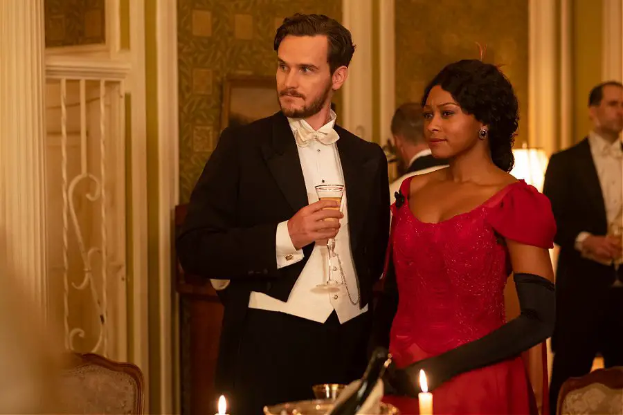 a white man standing next to a Black woman in a red dress, Shanice Banton portraying Violet Hart