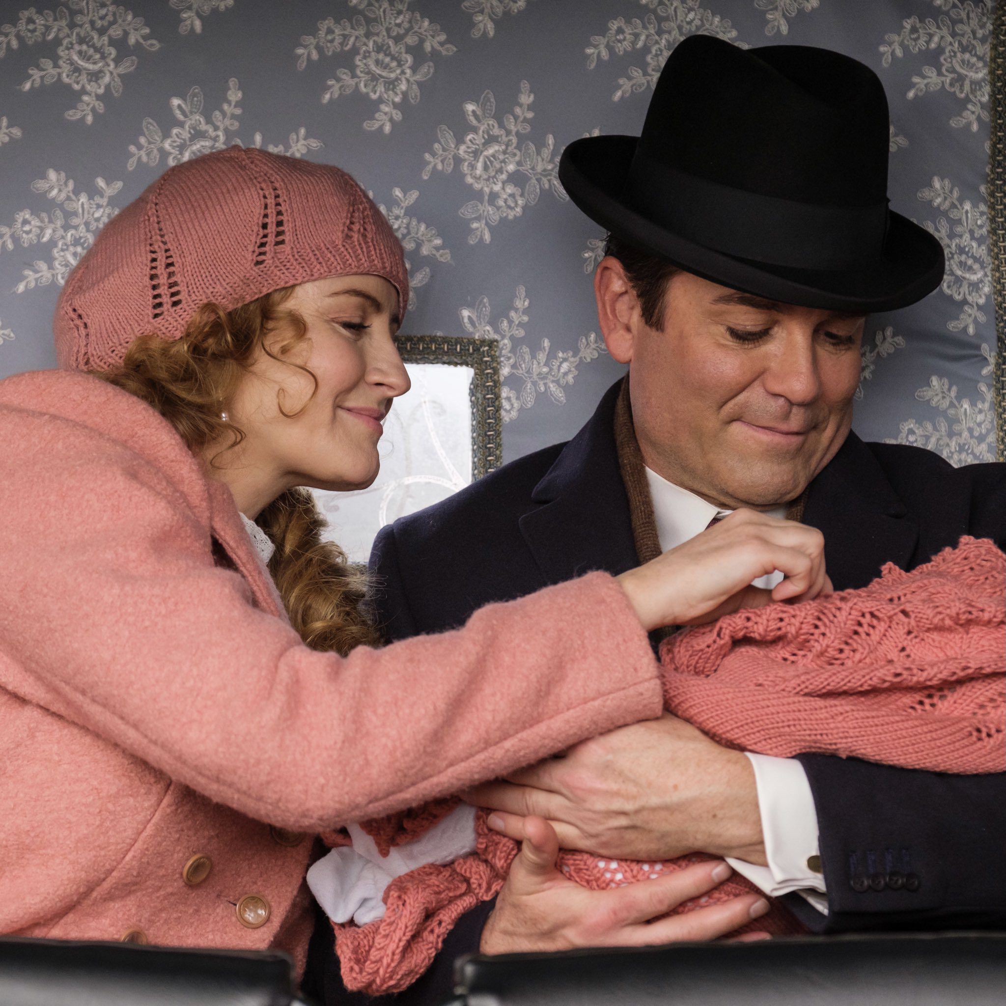 a white woman and white man (yannick bisson)  holding a baby (Murdoch Mysteries)