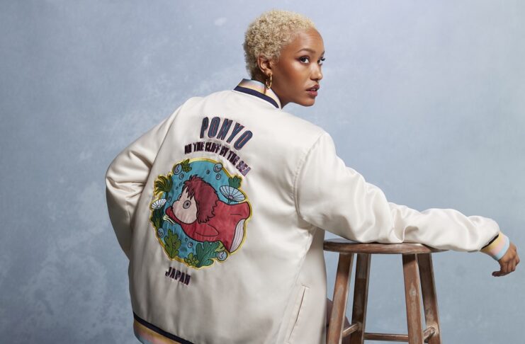 Black person with short hair wearing a cardigan that has Ponyo on the back from Boxlunch