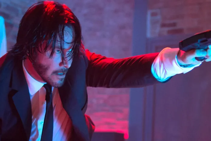 Keanu Reeves as John Wick points a gun towards the right