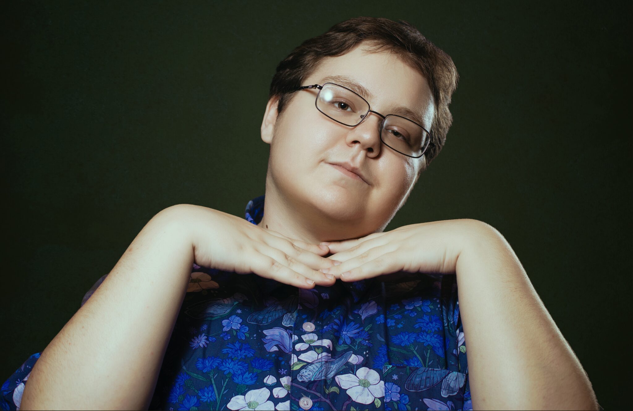 A photo of Irving B. He is a white trans masculine person in a purple patterned shirt.